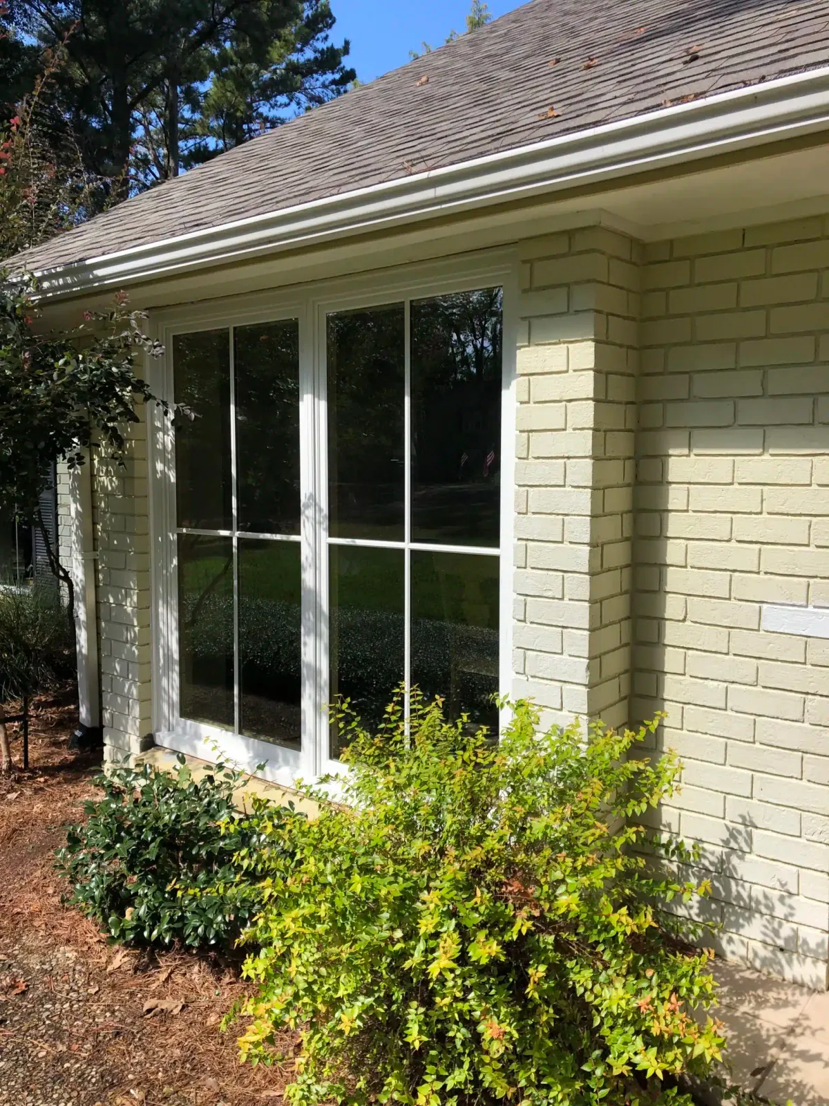 Older painted-brick home with new white windows installed