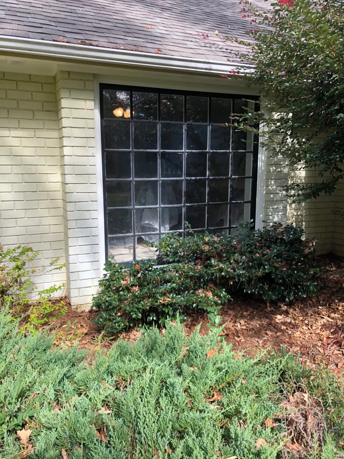 Before: older painted-brick home with an old divided-light window