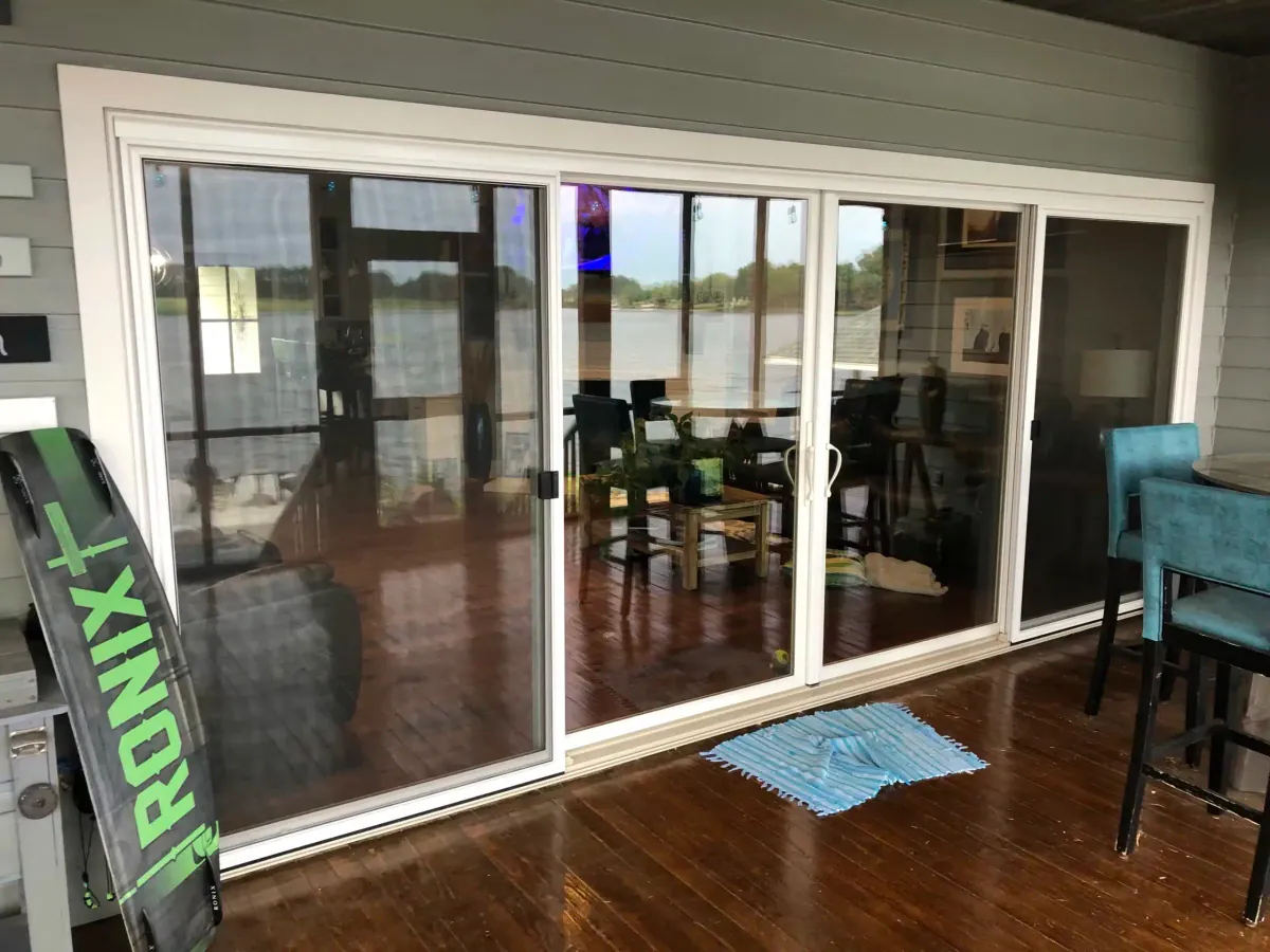 New white sliding glass door opening onto a deck with a lake view