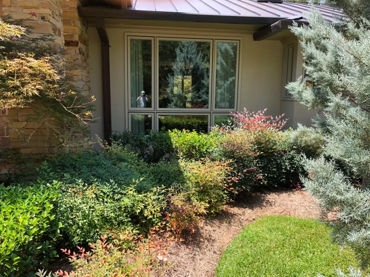 After: stone home with the new picture window framed by landscaping