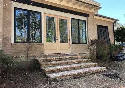 New French doors and windows on a brick home with brick steps